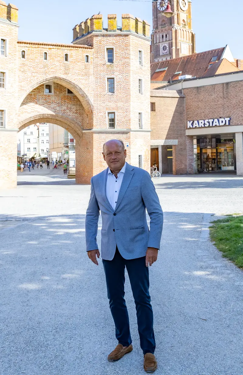 Eine belebte Szene in Landshut mit dem historischen Stadttor und dem Turm, wo die Kommunalwahl 2026 vorbereitet wird.